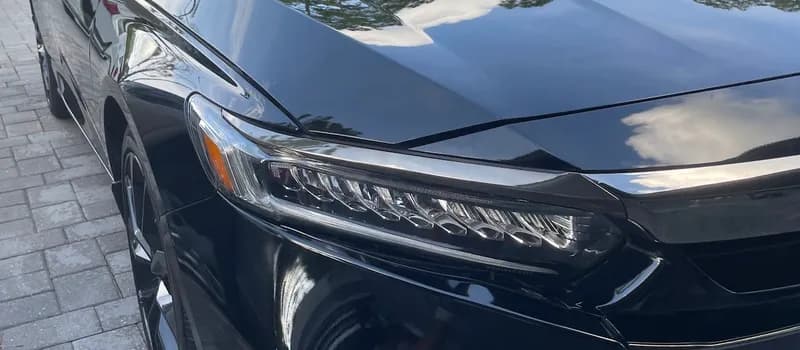 Glossy black sedan with mirror-like paint after professional detailing in North Port, FL