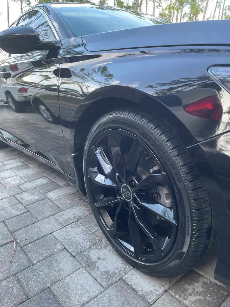 Mirror-like gloss on black Audi paint and wheel after paint correction in North Port, FL